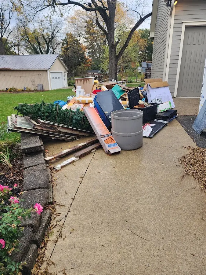 Dumpster being loaded with debris for 12 Yard Dumpster Rental in Metuchen